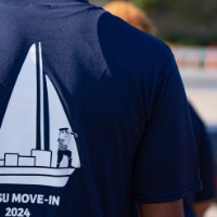 The back of a t-shirt that says "GVSU Move-In 2024" with a sailboat above it and Louie the Laker on the sailboat